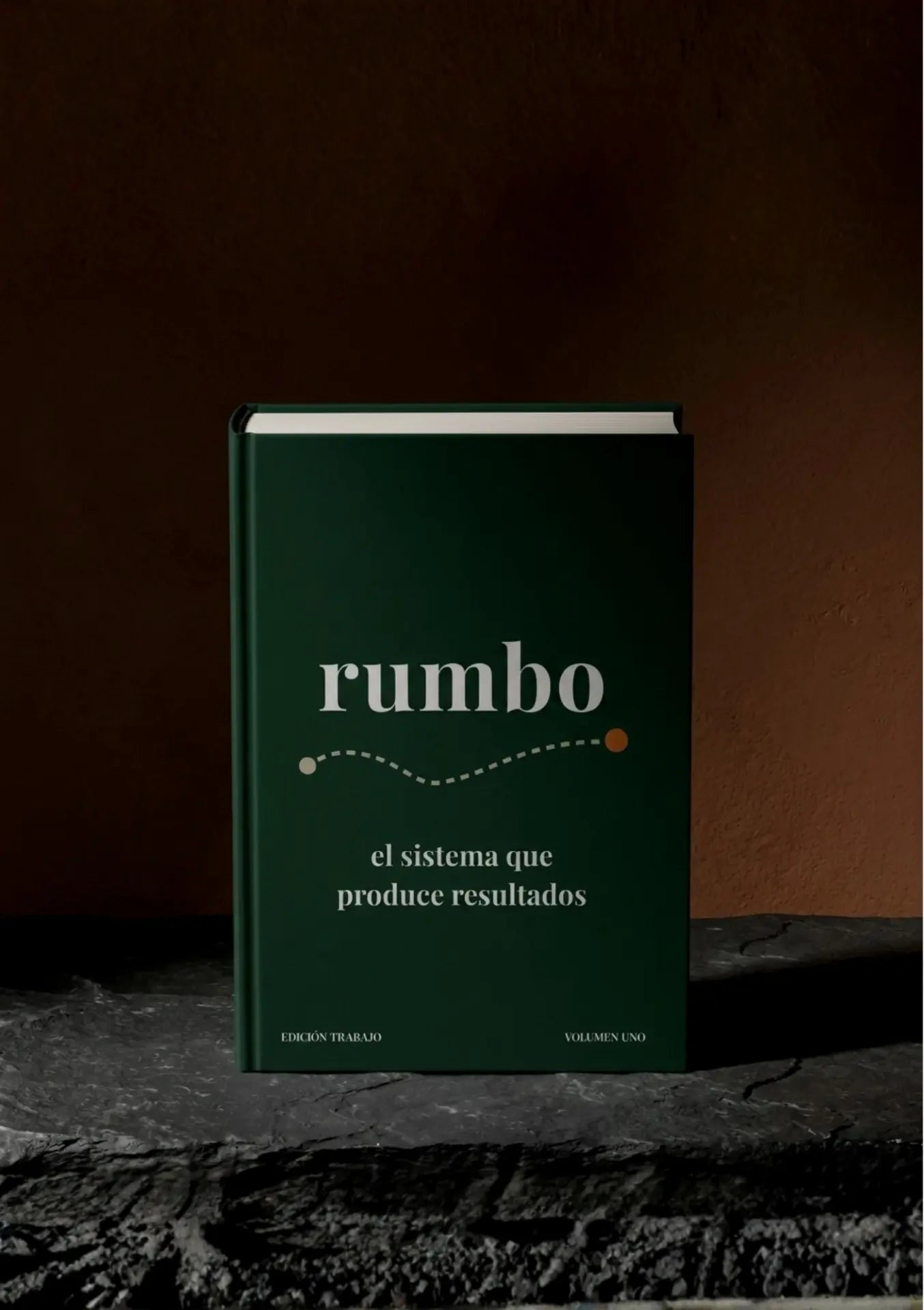 El cuaderno rumbo de pie sobre piedra, contra una pared cálida.